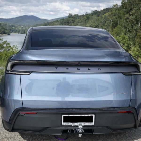 Back view of a Tesla Juniper with Tow Bar and a scenic background of trees and water.