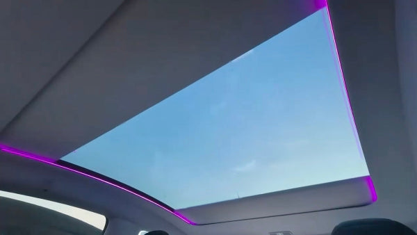 Electric Sunshade For Tesla Model Y Juniper with a panoramic sunroof showing a blue sky and LED Lights in sunshade