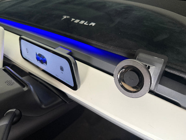 Car dashboard matv with Tesla logo and magsafe phone mount.